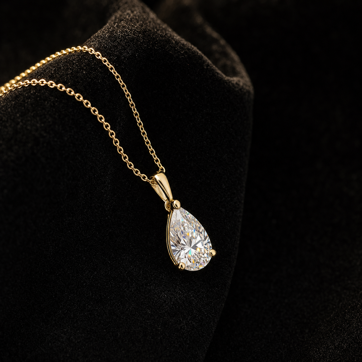 Luminia pear-cut moissanite pendant in gold on black velvet